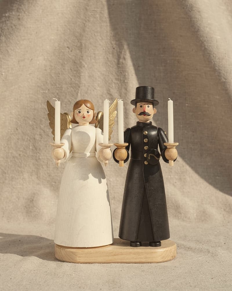 Ein Lichterpaar: ein Engel in Weiß mit goldenen Flügeln und ein Bergmann in Schwarz, jeder mit zwei weißen Kerzen.
