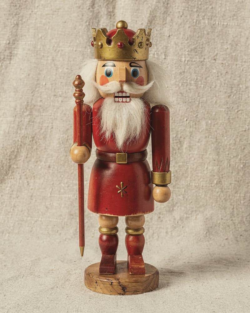 A nutcracker king in a red robe and gold crown, with white beard and scepter.