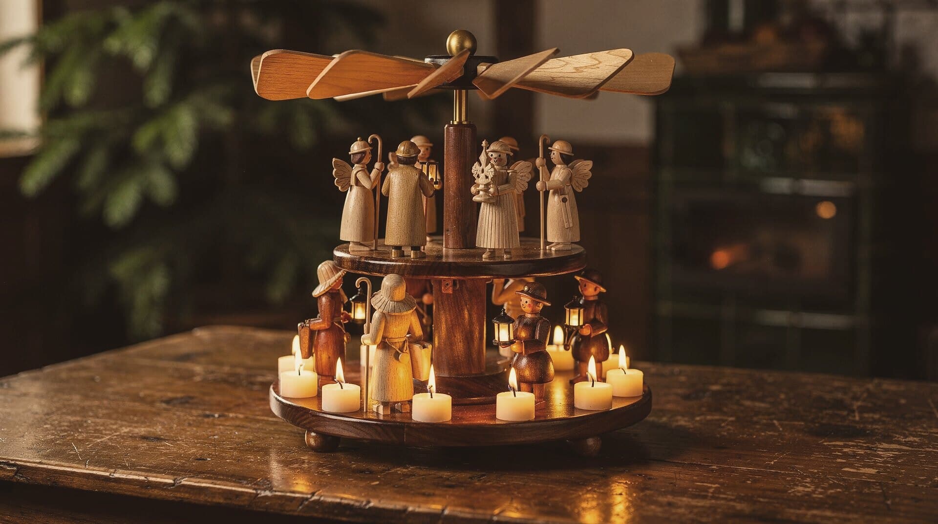 A two-tier pyramid turning on a parlor table, its candles lit, a tiled stove glowing behind.